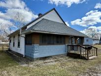 Charming home featuring a covered porch, gray roof, and a well-maintained exterior at 823 Collier St, Indianapolis, IN 46241