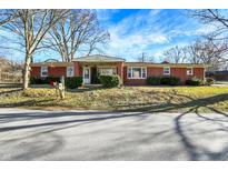 Charming brick ranch home with mature trees and a well-maintained front yard under a bright blue sky at 8525 Edith St, Martinsville, IN 46151