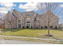 Beautiful brick home with a well-manicured front lawn and mature tree at 10560 Power Dr, Carmel, IN 46033