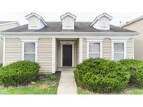 Charming home featuring dormer windows, black front door, and lush green bushes framing the entrance at 12243 Belfry Dr, Noblesville, IN 46060