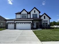 Stunning two-story home with a three car garage and manicured lawn at 15871 Vitalize Run, Fishers, IN 46040