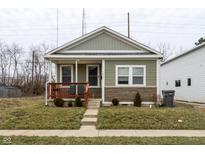 Charming home featuring stylish green siding, stone accents, and a cozy front porch at 1820 E Maryland St, Indianapolis, IN 46201
