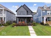 Charming two-story home with a well-manicured lawn, covered porch, and patriotic American flag at 2026 Alvord St, Indianapolis, IN 46202
