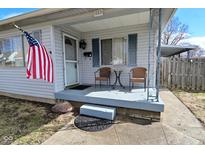 Inviting front porch with seating, complemented by charming blue shutters and an American flag at 243 S 3Rd Ave, Beech Grove, IN 46107
