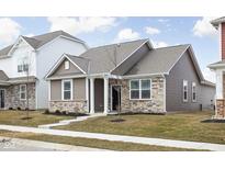 Charming single-Gathering home featuring stone accents, neutral siding, and a well-manicured lawn at 2556 Lamar Dr, Whitestown, IN 46075