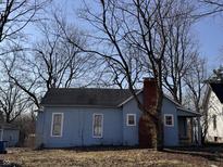 Charming single-story home with a brick chimney and light blue wood siding at 2933 E 56Th St, Indianapolis, IN 46220