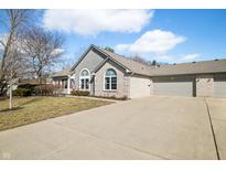 Charming single-story home with a well-maintained lawn and a spacious three-car garage at 5721 Quail Crossing Dr, Indianapolis, IN 46237