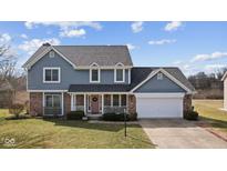Charming two-story home with a well-manicured lawn, a brick facade, and a welcoming front porch at 5732 Bold Ruler Dr, Indianapolis, IN 46237