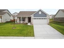 Charming single-story home with white brick and blue accents, lush green lawn, and a spacious driveway at 602 Tuscany Trl, Lapel, IN 46051