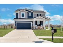 Two-story home boasts a front-facing two-car garage and a cozy front porch with rocking chairs at 6919 Sable Point Dr, Brownsburg, IN 46112