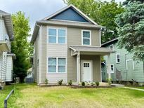 Charming two-story home with a well-maintained lawn and neutral-colored siding at 859 N Oakland Ave, Indianapolis, IN 46201