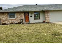 Charming brick home with a welcoming front yard, cozy front door and attached garage at 1408 Lawrence Way, Anderson, IN 46013