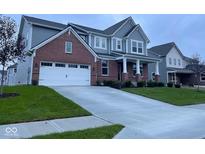 Beautiful two-story home featuring a brick facade, attached two-car garage, concrete driveway, and a well-maintained lawn at 15408 Brown Jack Dr, Fishers, IN 46040