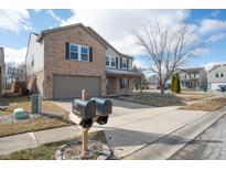Charming two-story home featuring a brick facade, attached garage, and well-maintained front yard on a sunny day at 1841 Sonesta Ln, Indianapolis, IN 46217