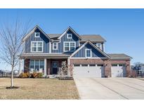 Charming two-story home with blue siding, brick accents, and a three-car garage under a clear blue sky at 19149 Gillcrest Dr, Noblesville, IN 46062