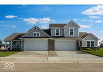 Charming home featuring a three car garage, gray siding, and a well manicured lawn at 2150 Aviary Ln, Danville, IN 46122