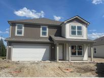 Two-story home with neutral colors, white trim, covered porch, and a two car garage at 24409 Stout St, Sheridan, IN 46069
