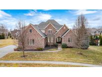 Elegant brick home featuring a manicured lawn and traditional architectural details at 3236 Wildlife Trl, Zionsville, IN 46077