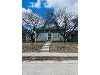 Quaint home with a stone facade, metal security door, and trees in front under a bright sky at 428 N Alton Ave, Indianapolis, IN 46222