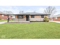 Charming brick home featuring a covered porch and manicured front lawn at 714 S 4Th Ave, Beech Grove, IN 46107