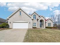 Charming two-story home features a brick facade, attached two car garage, and manicured lawn at 7370 Chestnut Hills Blvd, Indianapolis, IN 46278