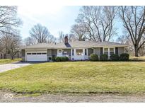 Charming single-story home featuring an attached garage, manicured lawn, and classic brickwork at 7950 Barlum Dr, Indianapolis, IN 46240