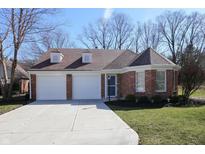 Charming single-story brick home featuring an attached two-car garage and a well-manicured front lawn at 9690 River Oak E Ln, Fishers, IN 46038
