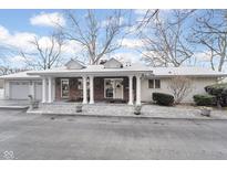 Ranch-style home featuring a covered porch with white columns and a well-manicured front yard with mature trees at 1020 W Riverview Dr, Anderson, IN 46011