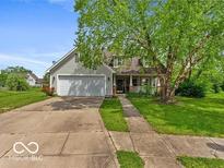 Charming home featuring a well-manicured lawn, inviting porch, and attached two-car garage at 11215 Cowan Lake Ct, Indianapolis, IN 46235