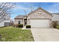 Charming brick home with a two-car garage, well-manicured lawn, and inviting front entrance at 11729 Rossmore Dr, Indianapolis, IN 46235