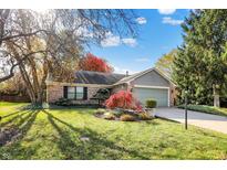 Charming single-story brick home featuring a well-manicured lawn and mature trees at 12601 Slippery Rock Rd, Indianapolis, IN 46236