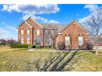 Stunning two-story red brick home with meticulously maintained landscaping and a lush green lawn at 13788 Four Seasons Way, Carmel, IN 46074