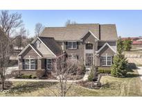 Stunning two-story brick home with meticulous landscaping, black shutters, and beautiful architectural details at 14034 Wicklow Ln, Fishers, IN 46040