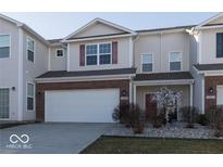 Well-maintained townhouse featuring a two-car garage and welcoming front entrance at 14309 Shooting Star Dr, Noblesville, IN 46060