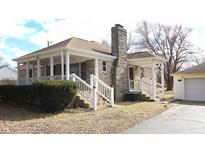 Charming single-Gathering home featuring a stone chimney, inviting front porch, and detached garage at 1739 Forest Dr, Indianapolis, IN 46227