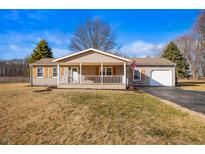 Charming single-story home featuring a welcoming front porch, attached garage, and well-maintained lawn at 3226 E 300 N, Anderson, IN 46012