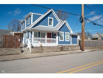 Charming blue two-story home with a covered front porch and well-maintained landscaping at 3406 E 20Th St, Indianapolis, IN 46218