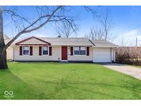 Charming single-story home with a well-manicured lawn, attached garage, and inviting red door at 3732 Wellington Ave, Indianapolis, IN 46226