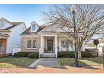 Charming brick and siding home featuring a covered porch and landscaped front yard at 4215 Heyward Pl, Indianapolis, IN 46250