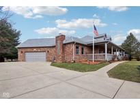 This attractive home boasts a convenient two-car garage, a sprawling driveway, and a lovely, covered porch at 520 Denny Dr, Mooresville, IN 46158
