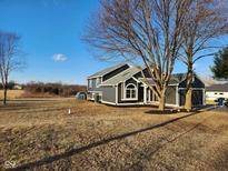 Two-story home with a modern gray exterior, attached garage and mature trees in a grassy yard at 6130 E 169Th St, Noblesville, IN 46062