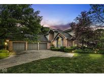 Charming brick home featuring a three-car garage and well-maintained landscaping, and a beautiful lawn at 7645 Ballinshire N, Indianapolis, IN 46254