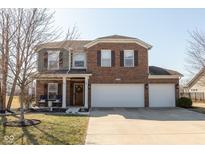 Charming two-story home featuring brick and siding, a welcoming front porch, and a spacious three-car garage at 7675 Winding Lake S Dr, Noblesville, IN 46062