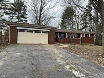 Charming one-story brick home with an attached garage and a driveway at 8328 S Franklin Rd, Indianapolis, IN 46259