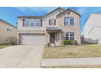 Charming two-story home with a well-maintained lawn, brick facade, attached garage, and neutral color scheme at 10294 Lothbury Cir, Fishers, IN 46037