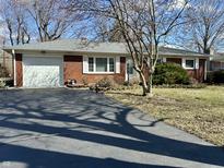 Red brick ranch-style home with attached garage and long asphalt driveway at 1031 Schleicher Ave, Indianapolis, IN 46229