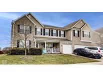 Charming two-story home featuring a covered front porch and a two-car garage at 10535 Pokagon Way, Indianapolis, IN 46239