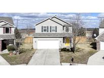Charming two-story home featuring light siding, a two-car garage, and a welcoming yellow front door at 15564 Old Pond Cir, Noblesville, IN 46060