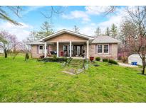 Charming brick home featuring a covered porch and a well-maintained front yard with mature trees and landscaping at 1794 Bell Rd, Morgantown, IN 46160