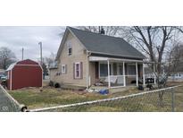 A two-story home featuring a covered front porch, neutral siding, and a detached shed in the backyard at 2212 S Delawanda Ave, Muncie, IN 47302